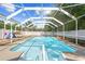 A refreshing in-ground pool is featured in this screened-in lanai and backyard at 7466 Jonquil Pl, Weeki Wachee, FL 34607