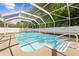 Inviting screened pool boasts clear water, white fencing, and ample space for relaxation and entertainment at 7466 Jonquil Pl, Weeki Wachee, FL 34607