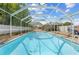 This large screened-in pool has clear water, white fencing, and ample space for recreation and lounging at 7466 Jonquil Pl, Weeki Wachee, FL 34607