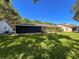 Beautiful backyard featuring lush lawn, screened enclosure, and a cozy outdoor space at 7700 Fairlawn Dr, Hudson, FL 34667
