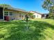 Serene backyard featuring lush grass, mature trees, and a charming old-fashioned water pump at 7700 Fairlawn Dr, Hudson, FL 34667