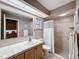 Bathroom showcasing tile shower, tiled vanity and a large mirror at 7700 Fairlawn Dr, Hudson, FL 34667