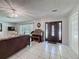 Spacious entryway with tiled floor features a wooden door, chandelier, and a vintage musical instrument at 7700 Fairlawn Dr, Hudson, FL 34667