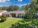 Inviting single-story home with a lush green lawn and mature trees, creating a serene and picturesque setting at 7700 Fairlawn Dr, Hudson, FL 34667