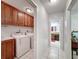 Convenient laundry room with sink, wood cabinets, and washer and dryer hookups at 7700 Fairlawn Dr, Hudson, FL 34667