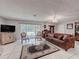 Cozy living room showcasing tile floors, large windows, a plush sofa, and elegant decor elements at 7700 Fairlawn Dr, Hudson, FL 34667