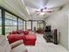 Bright sunroom with ample seating, a ceiling fan, and tile flooring throughout at 7700 Fairlawn Dr, Hudson, FL 34667