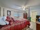 Bedroom features a four-poster bed, ceiling fan, and tile flooring at 7700 Fairlawn Dr, Hudson, FL 34667