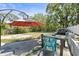 Backyard patio featuring an outdoor table, chairs, umbrella, and rock water feature, surrounded by lush greenery at 8240 Gulf Way, Hudson, FL 34667