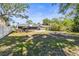 Expansive backyard featuring a covered patio, fire pit, mature trees, and fenced yard, perfect for outdoor living at 8240 Gulf Way, Hudson, FL 34667