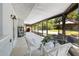 Relaxing screened patio with white wicker furniture and a view of the backyard at 8240 Gulf Way, Hudson, FL 34667