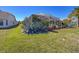 Spacious backyard with lush green grass and beautiful plants, including a screened pool enclosure at 8523 Regal Ln, Hudson, FL 34667