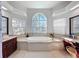 Luxurious bathroom featuring a large soaking tub, dual vanities, and plenty of natural light at 8523 Regal Ln, Hudson, FL 34667