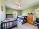 Green bedroom with bunk beds, a ceiling fan, neutral carpet, and a dresser; a room for ! at 8523 Regal Ln, Hudson, FL 34667