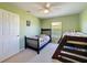 Green bedroom with a ceiling fan, neutral carpet, bunk beds, and access to a door; a room for ! at 8523 Regal Ln, Hudson, FL 34667
