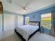 Light-filled bedroom features a queen bed, neutral carpet, blue walls, a ceiling fan, and two large closets at 8523 Regal Ln, Hudson, FL 34667
