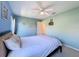 Light-filled bedroom features a queen bed, neutral carpet, two-tone walls, a ceiling fan, and a doorway at 8523 Regal Ln, Hudson, FL 34667