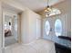 Bright foyer featuring tile flooring, a decorative chandelier, and an elegant glass-paneled double-door entrance at 8523 Regal Ln, Hudson, FL 34667