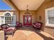 Inviting covered front porch featuring tiled flooring, a decorative wreath, and cozy wicker seating at 8523 Regal Ln, Hudson, FL 34667