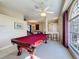 Open concept game room featuring a pool table, carpet, ceiling fan, natural light, and plenty of open space at 8523 Regal Ln, Hudson, FL 34667