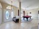 Bright room boasts tile floors, neutral walls, a pool table, and plenty of natural light from a large window at 8523 Regal Ln, Hudson, FL 34667