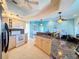 Open kitchen with granite countertops, stainless appliances, and tiled flooring, perfect for cooking and entertaining at 8523 Regal Ln, Hudson, FL 34667