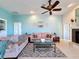 Comfortable living room with plush sofa, tile floors, ceiling fan, and plenty of natural light at 8523 Regal Ln, Hudson, FL 34667