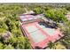 Aerial view of multiple outdoor tennis courts on a sunny day, offering an active lifestyle at 8523 Regal Ln, Hudson, FL 34667