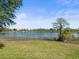 Backyard featuring lake view, grassy lawn, trees and natural landscaping at 9159 Trevino Dr, Weeki Wachee, FL 34613