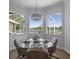 A breakfast nook boasts a glass table, seating for four, and views of the lake and lanai beyond at 9159 Trevino Dr, Weeki Wachee, FL 34613