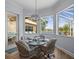A breakfast nook features a glass table, four chairs, and views of the screened-in lanai and lake at 9159 Trevino Dr, Weeki Wachee, FL 34613