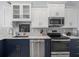 Modern kitchen featuring stainless steel appliances, granite countertops, and elegant white and navy cabinetry at 9159 Trevino Dr, Weeki Wachee, FL 34613