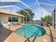 Inviting screened-in pool with lake views, brick patio, and comfortable lounge seating at 9159 Trevino Dr, Weeki Wachee, FL 34613