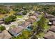 Aerial view of neighborhood homes, mature trees, with backyard swimming pools and green lawns at 951 Nodding Shade Dr, Brooksville, FL 34604