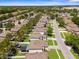 Aerial view of a residential neighborhood featuring houses with manicured lawns and nearby highway at 951 Nodding Shade Dr, Brooksville, FL 34604
