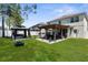 This backyard includes a covered patio, dining area, hot tub, fire pit and green space at 951 Nodding Shade Dr, Brooksville, FL 34604