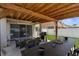 This covered patio features outdoor seating, a dining table, and a grill at 951 Nodding Shade Dr, Brooksville, FL 34604