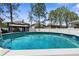 This backyard includes a fenced in above ground pool and outdoor lounge area at 951 Nodding Shade Dr, Brooksville, FL 34604