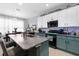 Open kitchen featuring an island with barstool seating, stainless steel appliances, and white upper cabinets at 951 Nodding Shade Dr, Brooksville, FL 34604