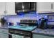 Stylish kitchen with new appliances and white upper cabinets and blue under-cabinet lighting at 951 Nodding Shade Dr, Brooksville, FL 34604