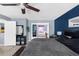 This main bedroom features blue accent walls, a ceiling fan, and access to an ensuite bathroom at 951 Nodding Shade Dr, Brooksville, FL 34604