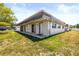 Exterior of unit with textured facade, low-pitched roof, small entry porch, and grassy front yard at 9811 Hidden Ln # 2, Port Richey, FL 34668