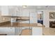 Galley kitchen with white cabinets and countertop space, open to living area at 9811 Hidden Ln # 2, Port Richey, FL 34668
