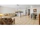 Open-concept living and kitchen area features tile flooring, white appliances, and dining set at 9811 Hidden Ln # 2, Port Richey, FL 34668