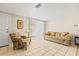 Cozy living room with tile floors, comfortable seating, and a large window with blinds at 9811 Hidden Ln # 2, Port Richey, FL 34668
