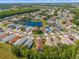 This is an aerial view of a residential area surrounding a serene lake with homes with mature trees and landscaping at 1013 Sweet Jasmine Dr, Trinity, FL 34655