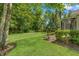Lush green backyard featuring mature trees and well-maintained lawn and a screened patio at 1013 Sweet Jasmine Dr, Trinity, FL 34655