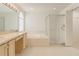 Bright bathroom with dual sinks, a soaking tub, and a glass-enclosed shower, creating a spa-like experience at 1013 Sweet Jasmine Dr, Trinity, FL 34655