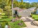 Well-maintained single-Gathering home featuring a two-car garage, manicured lawn, and tropical landscaping at 1013 Sweet Jasmine Dr, Trinity, FL 34655
