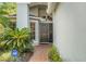Inviting entryway with a stylish front door, brick walkway, and lush greenery, protected by ADT at 1013 Sweet Jasmine Dr, Trinity, FL 34655